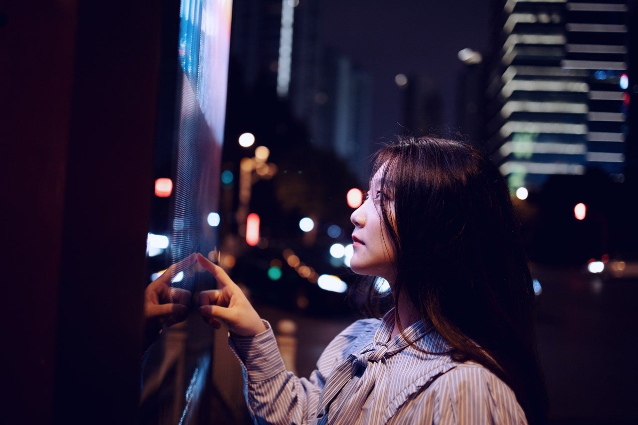 ws_woman_in_city_at_night_with_screen_hero